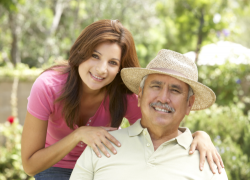 senior hispanic man with adult daughter in garden